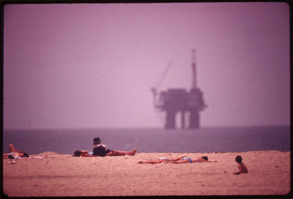 Sunbathers at Huntington Beach, and an oil platform offshore, May 1975 (Environmental Protection Agency)
